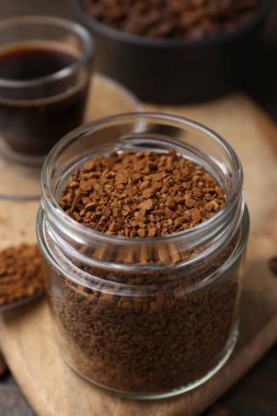 Cam kavanozdaki anlık kahve, masada sıcak içecek ve fasulye, yakın plan.