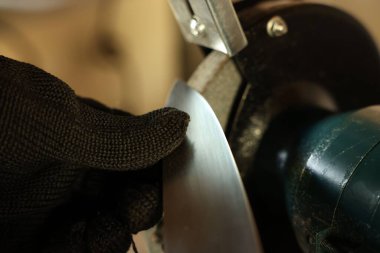 Bıçak keskinleştiren adam içeride, yakın plan.