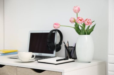 Modern dizüstü bilgisayarlı masa, kahve ve kırtasiye malzemesi.