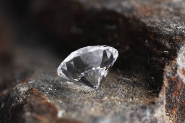 Taş yüzeyde güzel, parlak bir elmas, yakın plan.