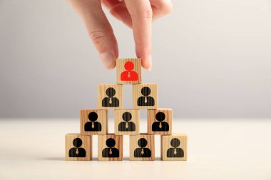 Dağılabilirsiniz. Diğerlerinin yanında kırmızı insan simgesiyle küp alan bir kadın. Masasında siyah olanlar, yakın plan.