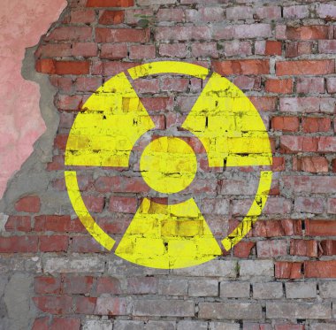 Eski tuğla duvarda sarı radyoaktif tabela. Radyolojik kirlilik