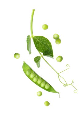 Yeşil bezelyeler ve kabuklar beyaz arkaplana düşüyor