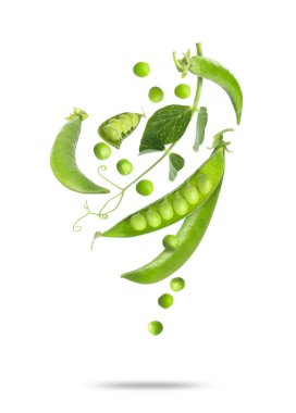 Beyaz arkaplana düşen yeşil bezelyeler ve kabuklar