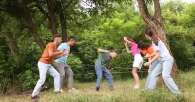 Takım oluşturma. Bir grup mutlu insan dışarıda örümcek ağı oynuyor.