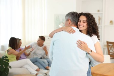 Mutlu arkadaşlar evde sarılıyor, seçici odaklanıyor.