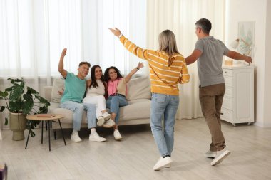 Mutlu arkadaşlar evdeki kanepede çiftleri selamlıyor.