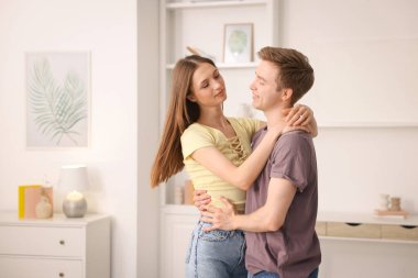 Mutlu genç çift evde dans ediyor.