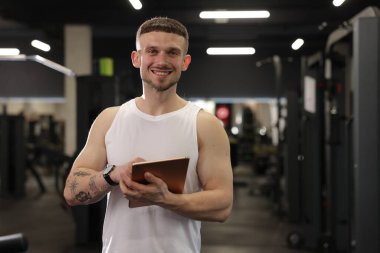 Spor merkezinde tableti olan kişisel antrenör. Metin için boşluk