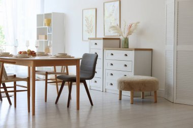 Yemek odasında güzel bir masa, sandalye ve dekor var. İç tasarım