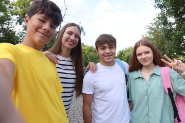 Bir grup genç parkta selfie çekiyor.