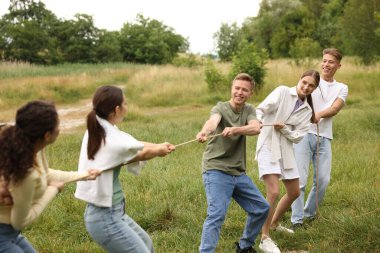 Takım oluşturma. Dışarıda halatla çekme oyunu oynayan bir grup mutlu insan.