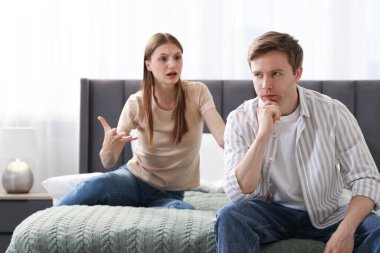 Kadın ve erkek evde yatakta kavga ediyorlar.