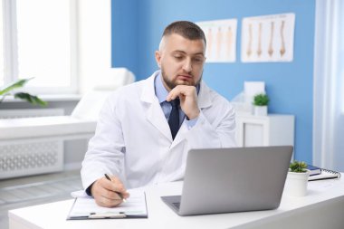 Klinikte bilgisayarla online danışmanlık yapan bir doktor