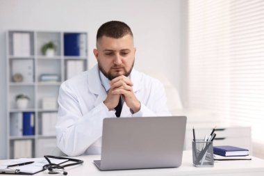 Klinikte bilgisayarla online danışmanlık yapan bir doktor