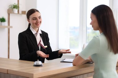 İçerideki resepsiyonda çalışan gülümseyen resepsiyonist.