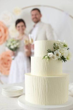 Mutlu evli çift içeride, masadaki düğün pastasına odaklan.