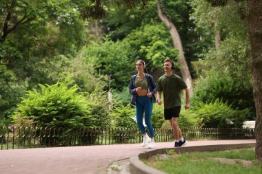 Parkta koşan kulaklıklı mutlu çift, düşük açılı görüş. Sabah egzersizi