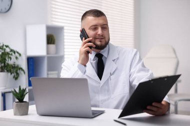 Akıllı telefonlu doktor klinikte online danışmanlık yapıyor.