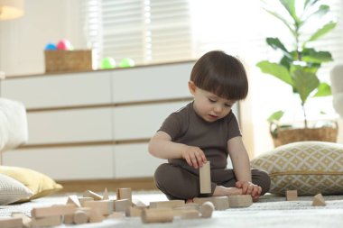 Evde ahşap yapı taşlarıyla oynayan sevimli küçük bir çocuk. Metin için boşluk