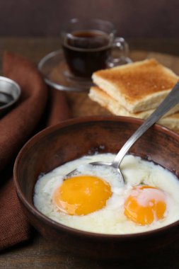 Geleneksel Asya kahvaltısı, yarı haşlanmış yumurta, kahve ve ahşap masada kızarmış ekmek, yakın plan.