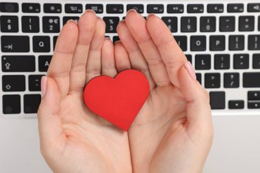 Online flört sitesi. Kalbi dizüstü bilgisayarın üstünde olan bir kadın.