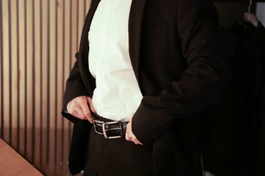 Zarif kıyafetli adam içeride hazırlanıyor, yakın plan.