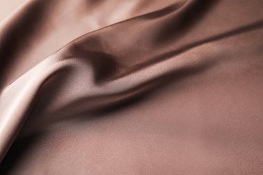 Arkaplan olarak buruşuk açık kahverengi ipek kumaş, yakın plan