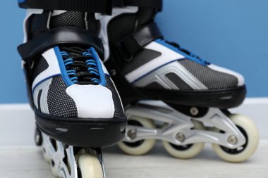 Açık mavi duvarın yanında paten çifti, yakın plan.