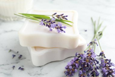 Sabun çubukları ve lavanta çiçekleri beyaz mermer masada, yakın plan.