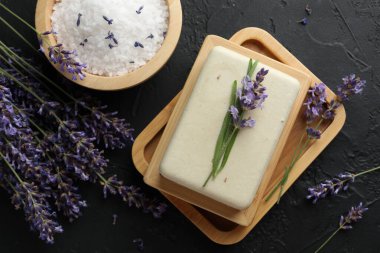 Aromatik sabun çubuğu, deniz tuzu ve lavanta çiçekleri koyu desenli masa, düz yatıyordu.