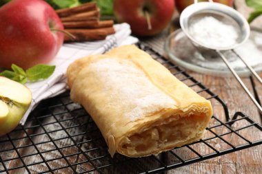 Lezzetli elmalı turta pudra şekeri, nane, meyve ve tarçınlı ahşap masa, yakın plan.