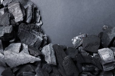 Gri arka planda siyah kömür parçaları, üst manzara. Metin için boşluk