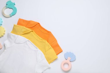 Beyaz arka planda bebek kıyafetleri ve aksesuarlar, düz yatış. Metin için boşluk