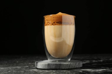 Lezzetli dalgona kahvesi koyu mermer masada.