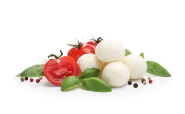 Lezzetli mozzarella peynir topları, domates, fesleğen ve biberler beyaz üzerine izole edilmiş.