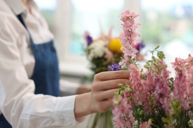 Çiçekçi dükkanda çiçek buketi yapıyor, yakın plan.