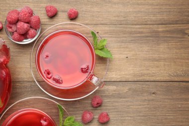 Cam bardaklarda ahududu çayı, tahta masada nane ve böğürtlen, düz yatak. Metin için boşluk