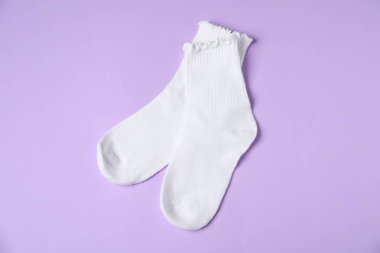 Menekşe arkaplanda bir çift rahat beyaz çorap, üst görünüm