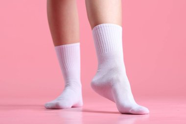 Pembe arka planda beyaz çoraplı kadın, yakın plan.