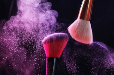 Siyah arkaplanda renk farlı makyaj fırçaları, yakın plan
