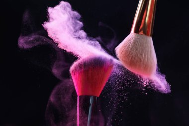 Siyah arkaplanda renkli göz gölgeli makyaj fırçaları, yakın plan