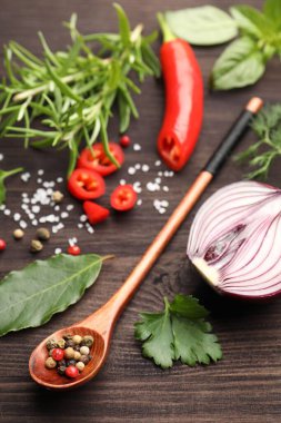 Farklı taze otlar ve baharatlar ahşap masada, yakın plan.