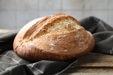 Tahta masada bir somun taze ekmek, yakın plan.