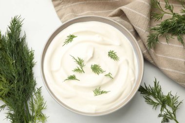 Lezzetli ekşi krema, beyaz masada dereotu, düz.