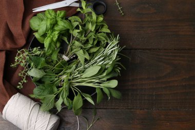 Farklı yeşil otlar kasede, makas ve tahta masa üzerinde sicim düz yerde. Metin için boşluk