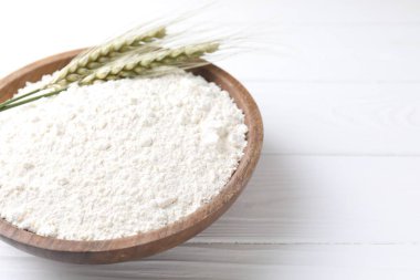 Un ve yeşil buğday, beyaz ahşap masadaki kasede, yakın plan. Metin için boşluk