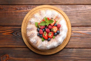 Tahta masada pudra şekeri ve böğürtlenli Lezzetli kek.