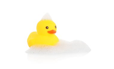 Aynada beyaz arka planda sevimli bir lastik ördek ve köpük.