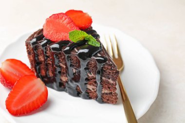 Çilek ve çatalla servis edilen çikolatalı kek, yakın plan.